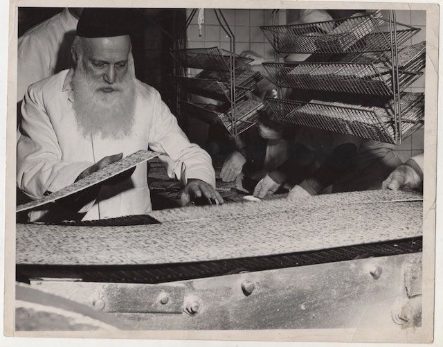 Rabbi Moshe Feinstein inspects matzo emerging from first floor oven, sometime in the late 1940s. Feinstein was one of the most influential figures in in Orthodox Judaism in the U.S. in the 20th century, and an expert in halachic law, the laws regarding the âkoshernessâ of food 
